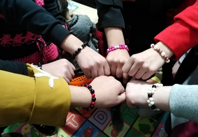 Geflüchtete Mädchen aus dem Projekt Girls Shine im Irak präsentieren ihre Armbänder