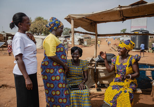 Kvinnor utanför en teshop i ett flyktingläger i Uganda