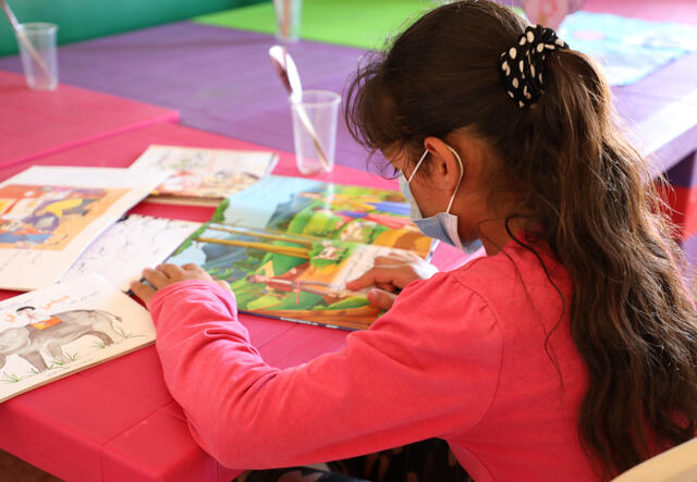 Gharam sitting with her schoolbooks at the IRC Centre