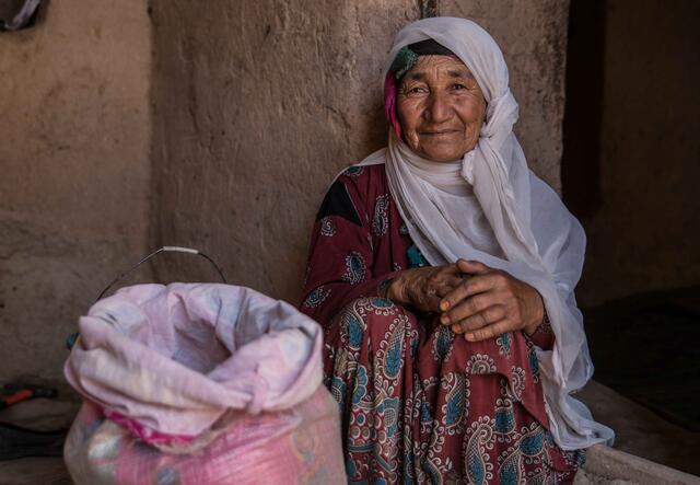 Fatima sitting next to a sack of grain