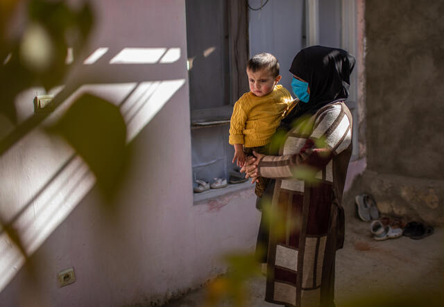 En kvinna leker med sin son utanför det hus hon hyr i Kabul, Afghanistan