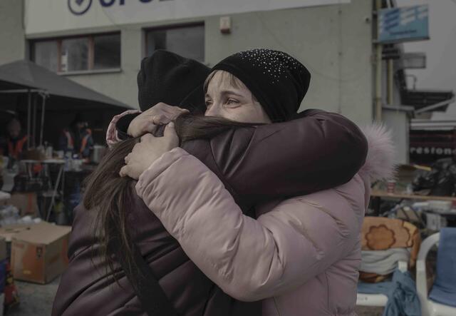 A mother and her daughter meet at the Medyka border crossing point, Poland