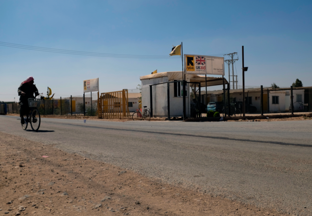 A man rides his bike past an IRC clinic set up at the Zaatari Camp