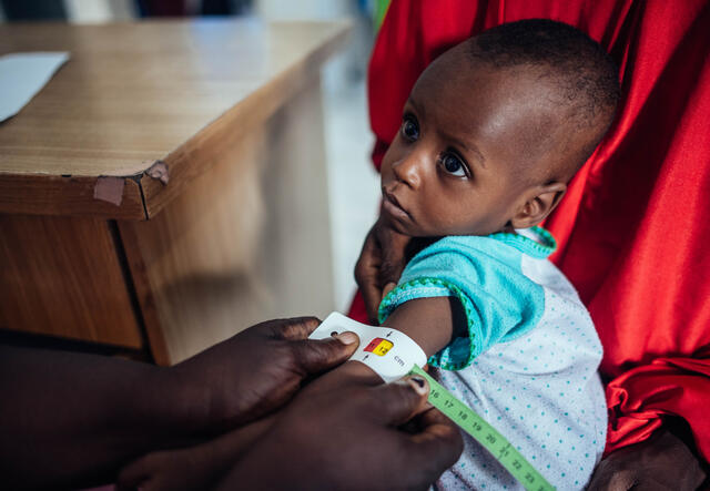 Mrs Rhoda Rufus, Stabilization center assistant, takes the arm measurement of baby Muhammad Ali, 10 months whilst been carried by his mother, Hafast Muhammad at Mashamari Stabilization center, Jere, Borno, Nigeria