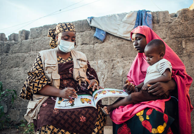 Fatima Wakilamtu, IRC Nutrition Officer, teaches Bilkisu Ahmed, 29, beneficiary, how to measure her child’s arm using a MURAC tape at her home in Maiduguri, Borno, Nigeria on Thursday, 23 September 2021.