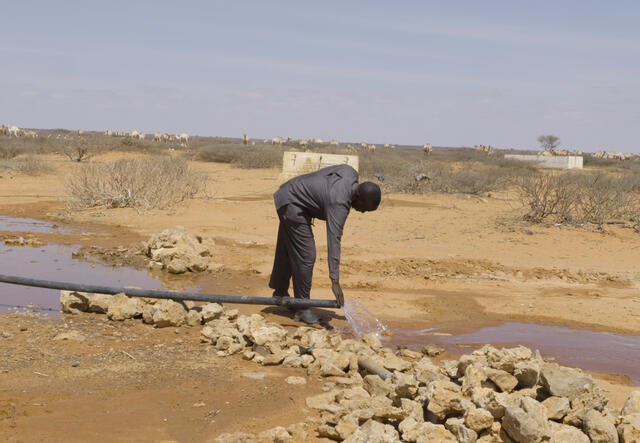 En man vid ett vattenrör i Somalia