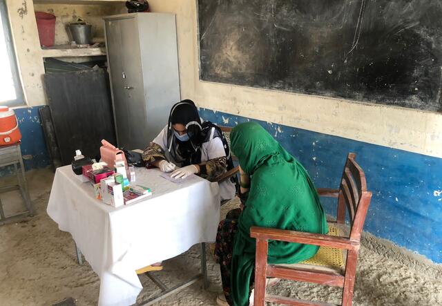 A woman is treated at a makeshift medical facility.