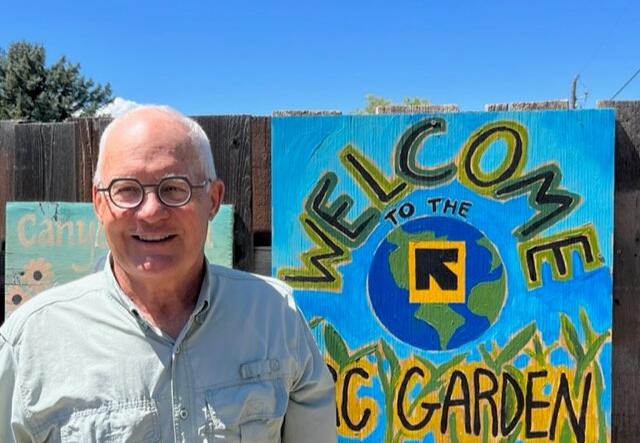 Del Draper standing in from of the New Roots community garden.