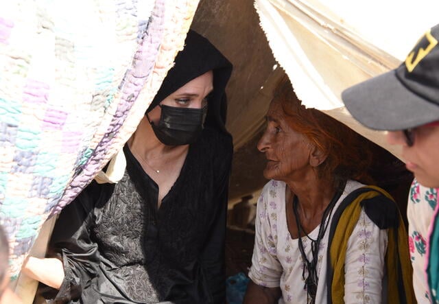 Jolie visits with a woman affected by flooding and Pakistan.