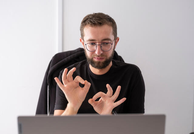 Deaf interpreter Oleksii signing via a video call