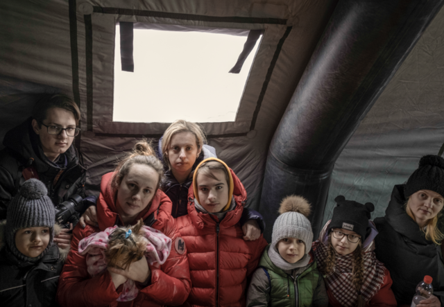 Geflüchtete aus der Ukraine versammeln sich in einem Zelt am Grenzübergang Medyka in Polen.