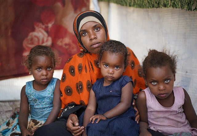 Bodor Ali Muhammad, 21, sits with her three daughters in Modhoor camp in Yemen.
