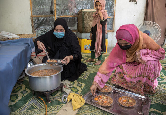 Barfi, IRC community health surveillance assistant leads a cooking class helped by Rahullah (in pink), IRC Community health volunteer.