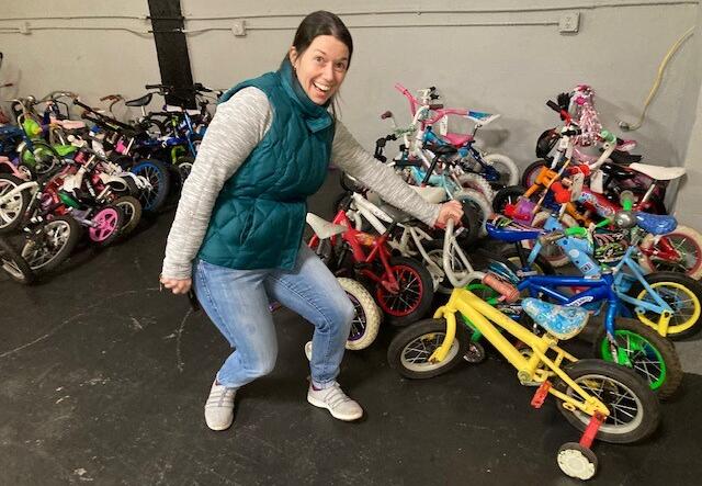 Youth Program Supervisor, Julie Goldberg, posing with a collection of bikes.