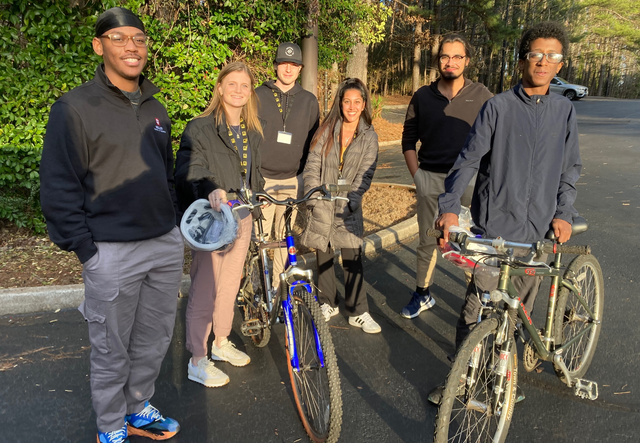 Six student volunteers from Indiana University Bloomington posing with a bike
