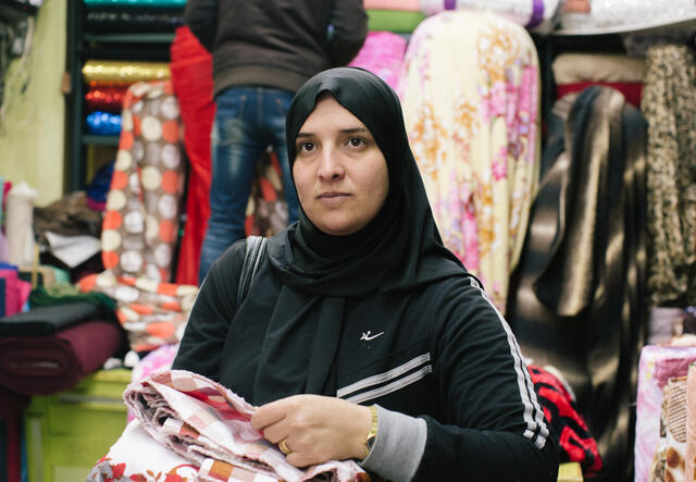 Rehab poses for a photo while shopping for fabrics at a store in Amman, Jordan.
