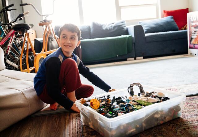 A kid from Afghanistan opening up toys during the holidays.