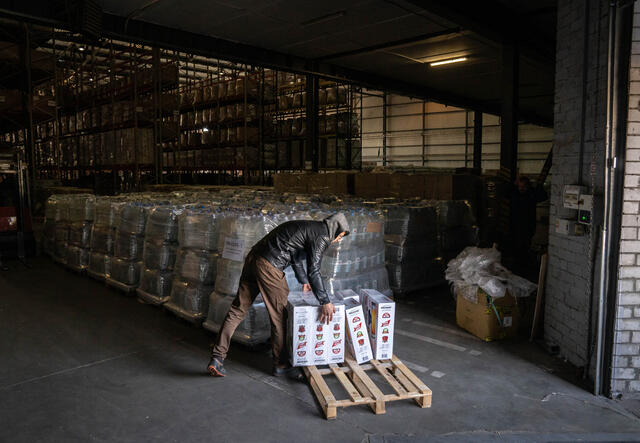 Man sorts crates with winter kits in IRC warehouse