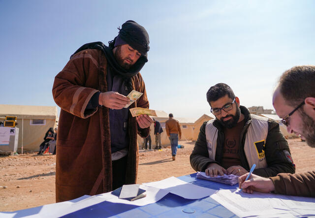 Man receives cash support from IRC staff in northern Syria.