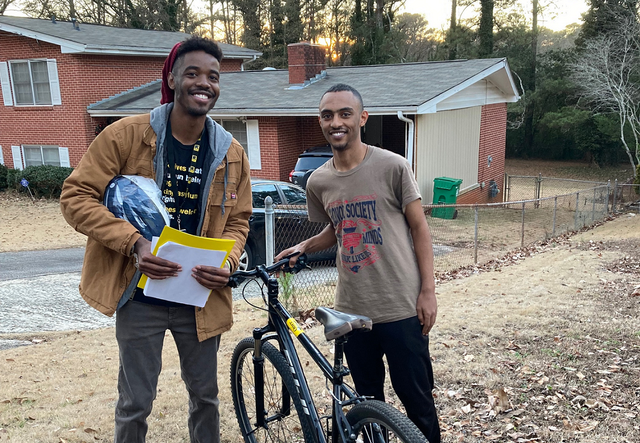Youth Student Support Specialist, Langston Jenkins, an an adolescent male posing with a bike in a Clarkston neighborhood.