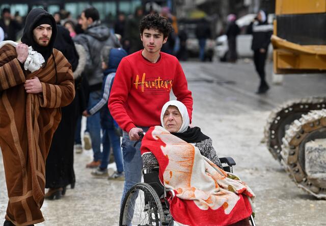 시리아 지진 발생 후 한 남성이 휠체어를 탄 할머니들을 밀고 있다.