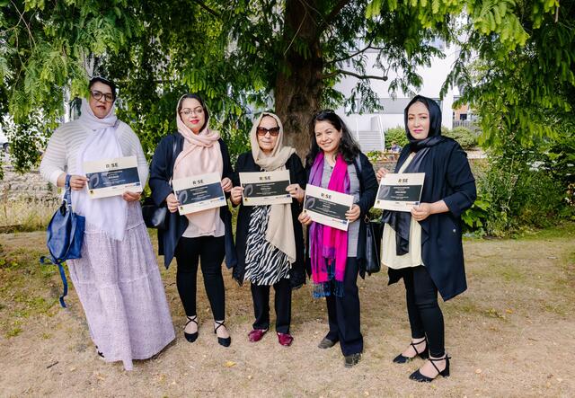 Five women standing together holding certificates