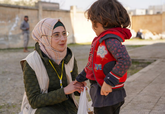 A young boy in northwest Syria receives food items from an IRC emergency response worker.