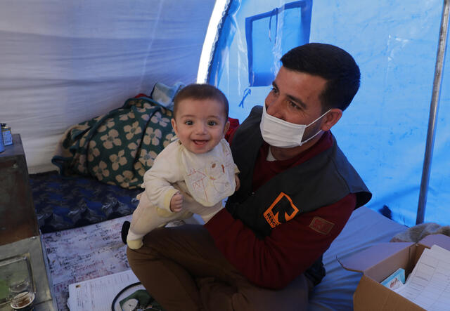 IRC doctor holds baby.