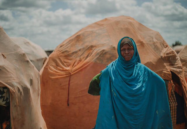 Bistra stands outside her makeshift shelter in Somalia.