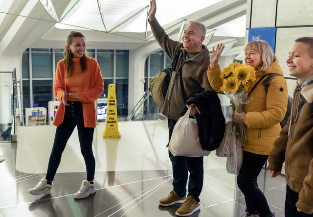 A Ukrainian family is greeted with flowers at the Wichita, Kansas airport.