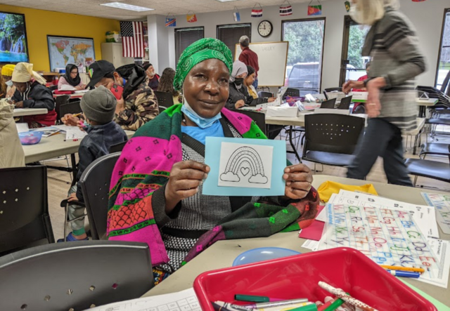 A Congolese woman in an IRC Atlanta Adult Education class holding up a drawing of a rainbow