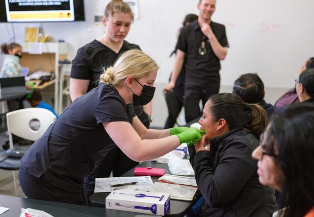 U of U dental students working on oral exam with IRC refugee