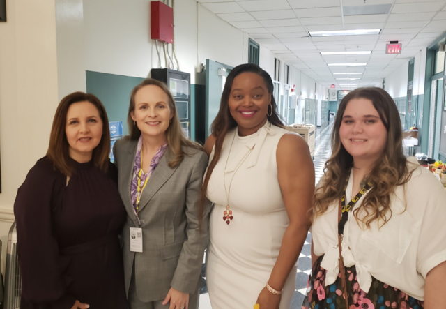 Alexis Powers (far right) standing with Jill Goodrich (second from the left) and two others.