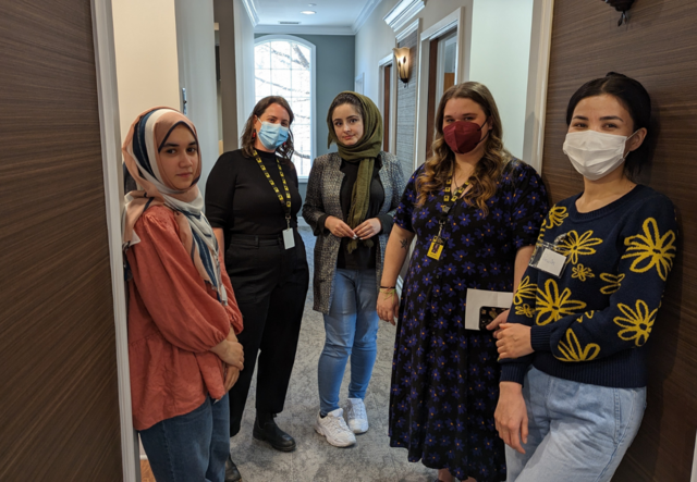 A group of five, including dental students and IRC Atlanta staff members, standing in a hallway.