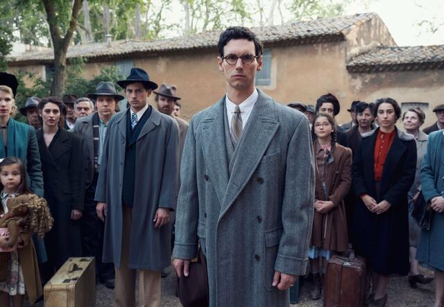 Still from Netflix series "Transatlantic"- Cory Michael Smith (playing Varian Fry) is center, surrounded by other cast members.