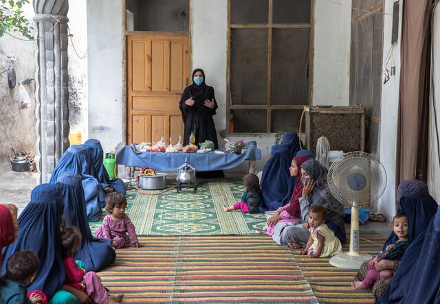 Mariam starts her cooking class in front of an audience of Afghan mothers and young women by presenting each ingredient for the recipe and their nutritional benefits.