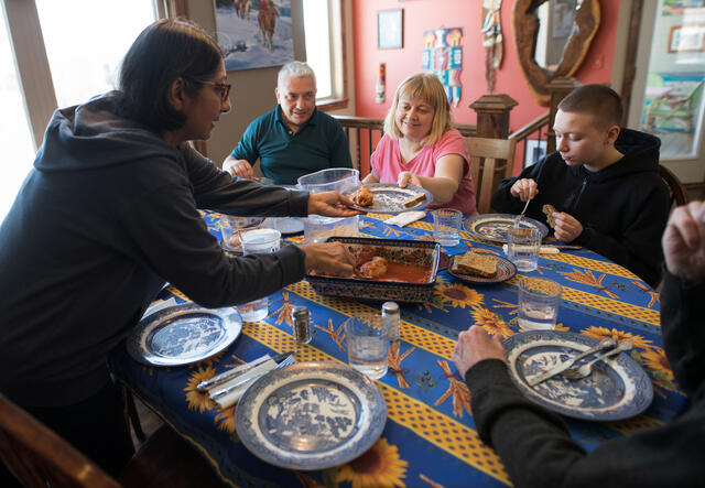 The Plegutsa family share a meal together with their sponsor family.