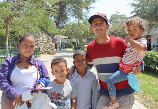 Reivid and Yosneida stand facing the camera with their three children.