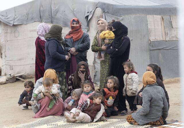 People living in a displacement camp attend a cholera awareness campaign run by the IRC. 