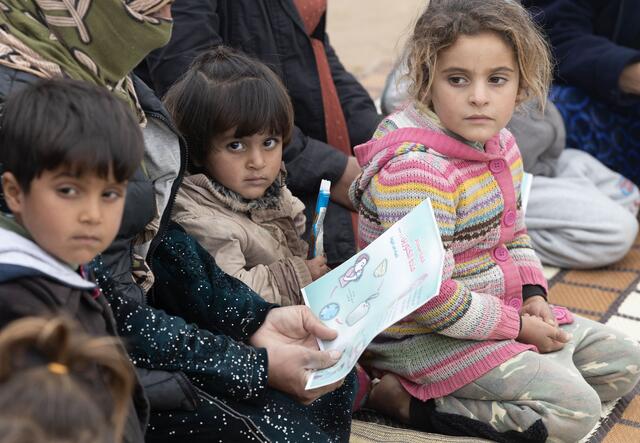 Children and their parents carefully listen to the health education session given at the camp. 