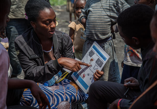 An IRC worker trains a community in the Democratic Republic of the Congo on safe health practices.