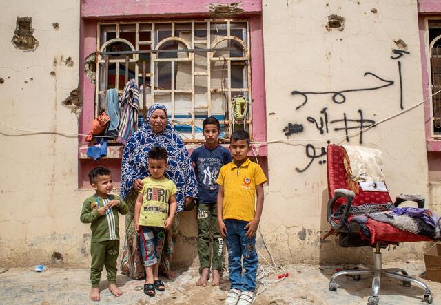 A portrait of Subiha and her grandchildren, standing in the Kilo-7 informal site in the Ramadi district of Anbar, where they live.