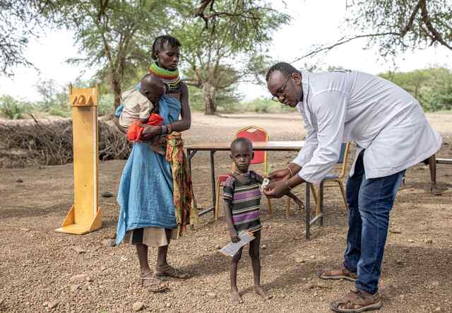 Dietisten Sammy undersöker en liten pojke för undernäring på landsbygden i Kenya.