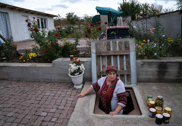 Olga från Ukraina står i trappen till hennes källare, där gömmer de sig när striderna blossar upp.