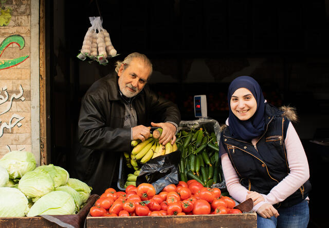 Ala'a stands with her father, Hussein Ali Fakih, outside their vegetable shop in Burj Hammoud, Beirut. 