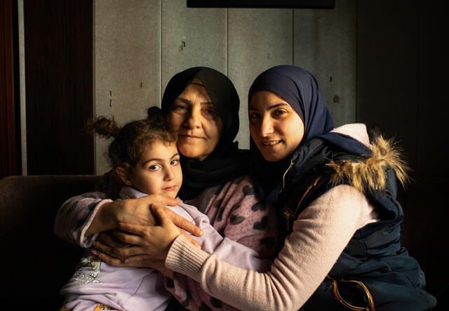 Ala'a with her mother and daughter, who all hug while facing the camera.