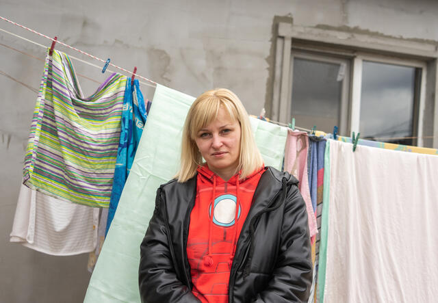 Tetiana standing in front of a clothes line full of laundry