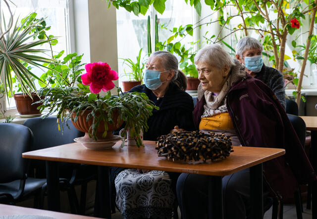 Alla sits beside one of her friends at the nursing home