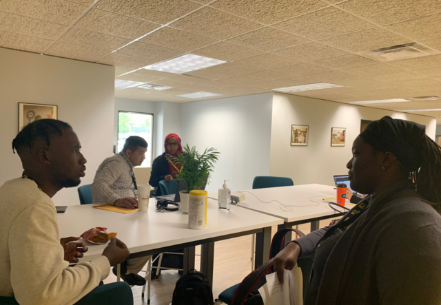 Four IRC Atlanta Logistics staff members gathered around a tall table in the IRC office.