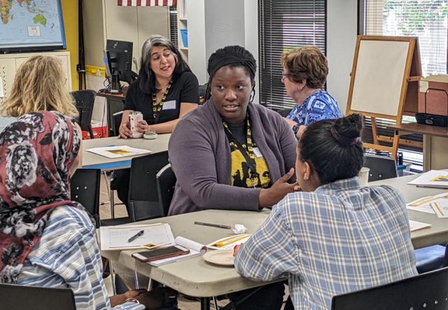 Shaina Applewhite speaking with a group of IRC Atlanta supporters in a English classroom.